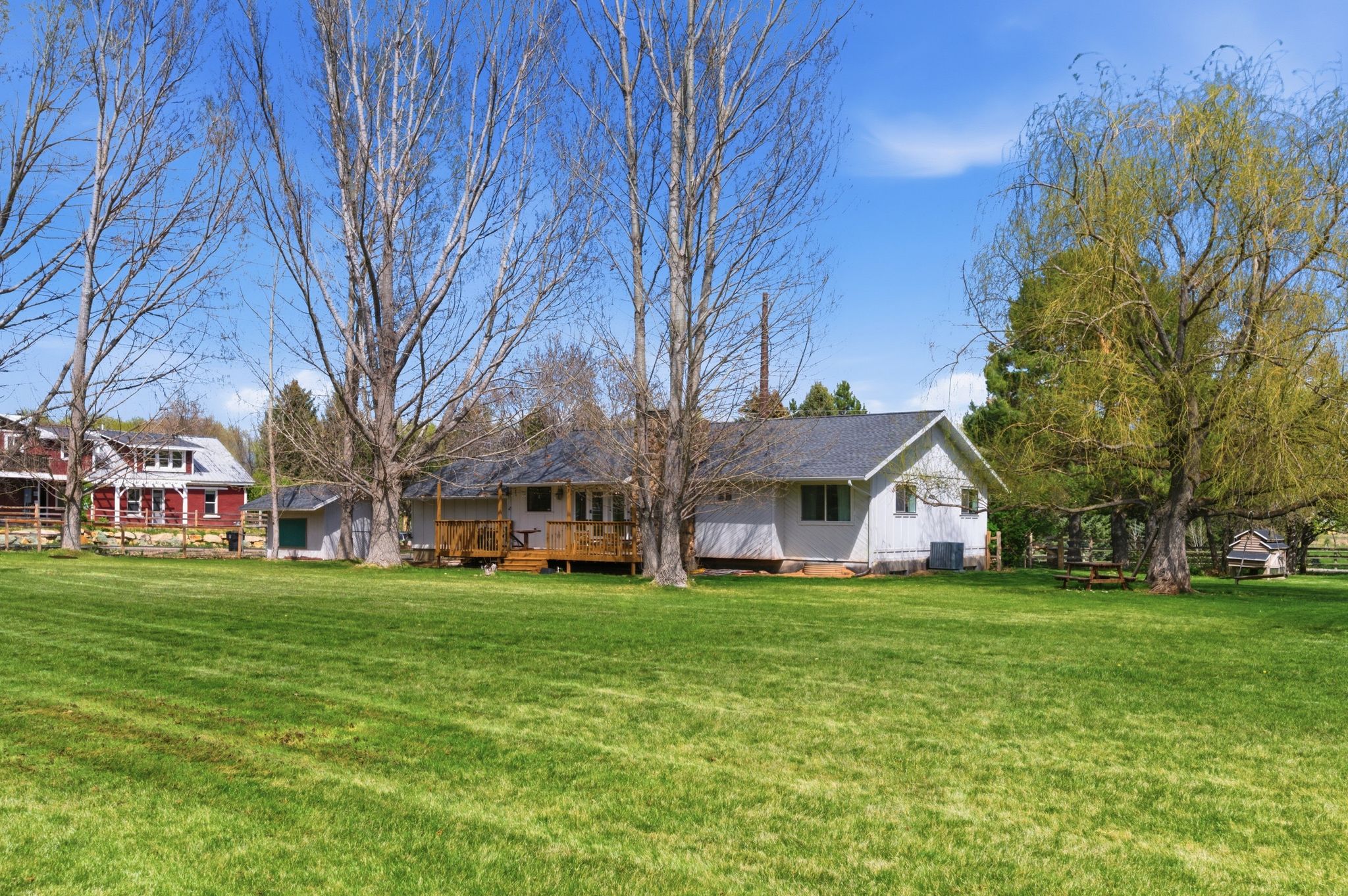 Back of the home tucked beneath mature shade trees
