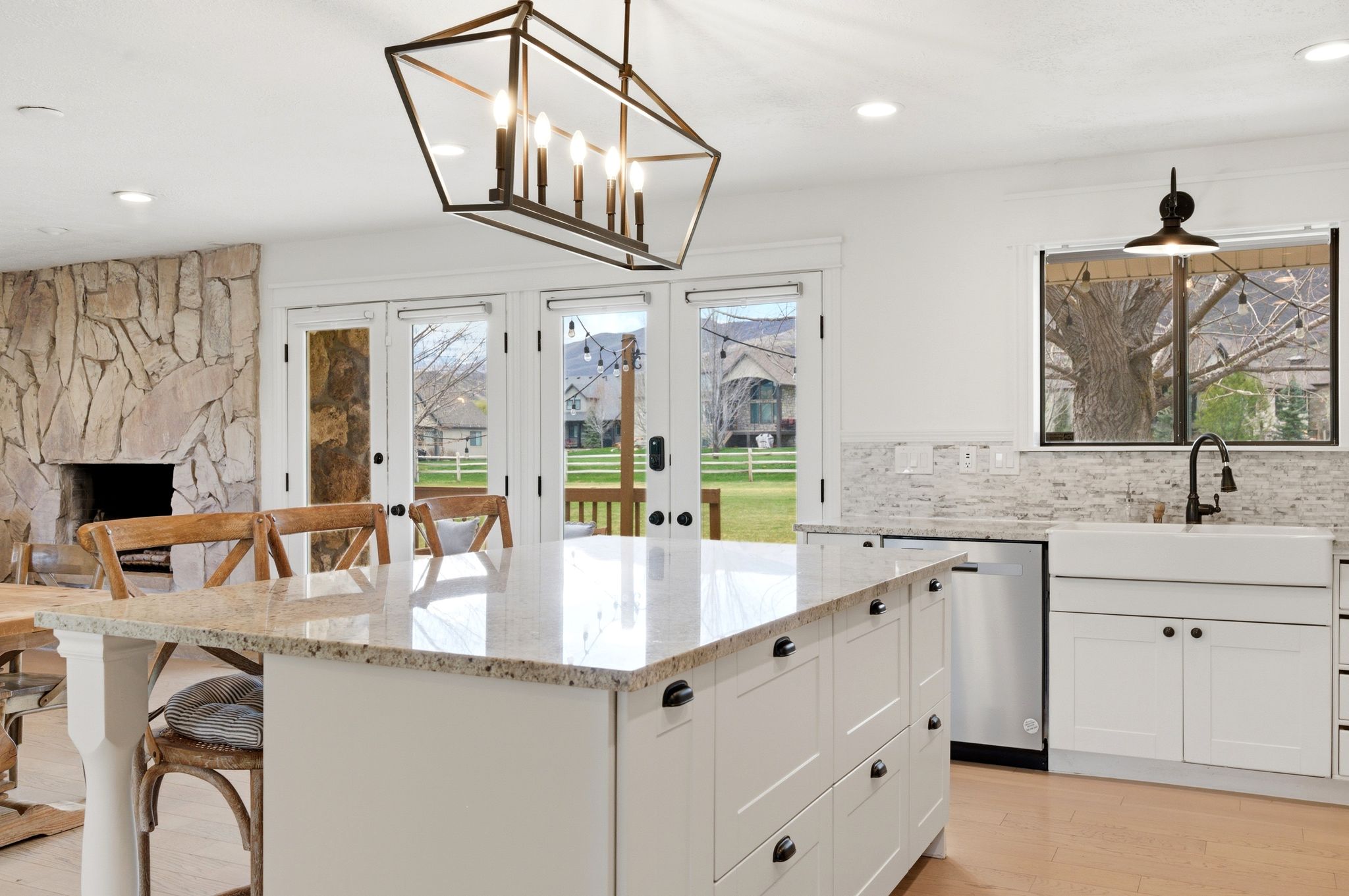 Kitchen island and lantern pendant with stone fireplace behind